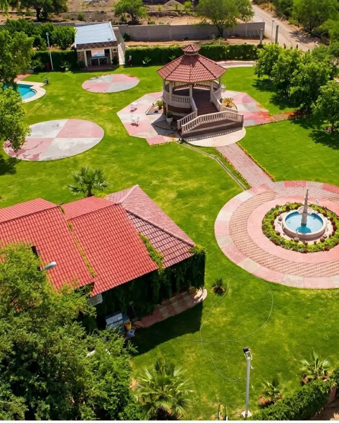 Vista aérea de los jardines, el kiosko, la fuente y un techo de teja roja