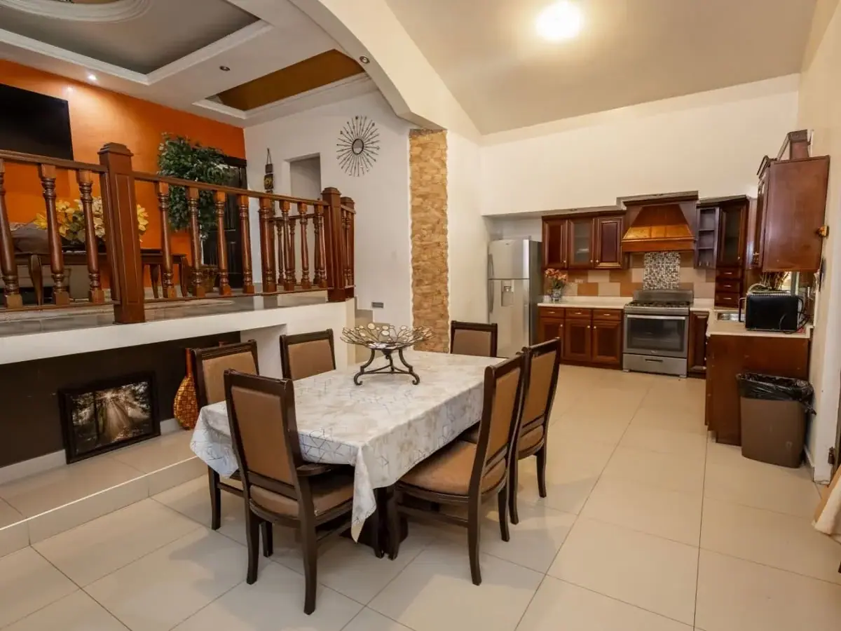 Comedor y cocina en un espacio amplio con barandal de madera